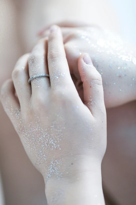 someone's hands are covered with white glitter