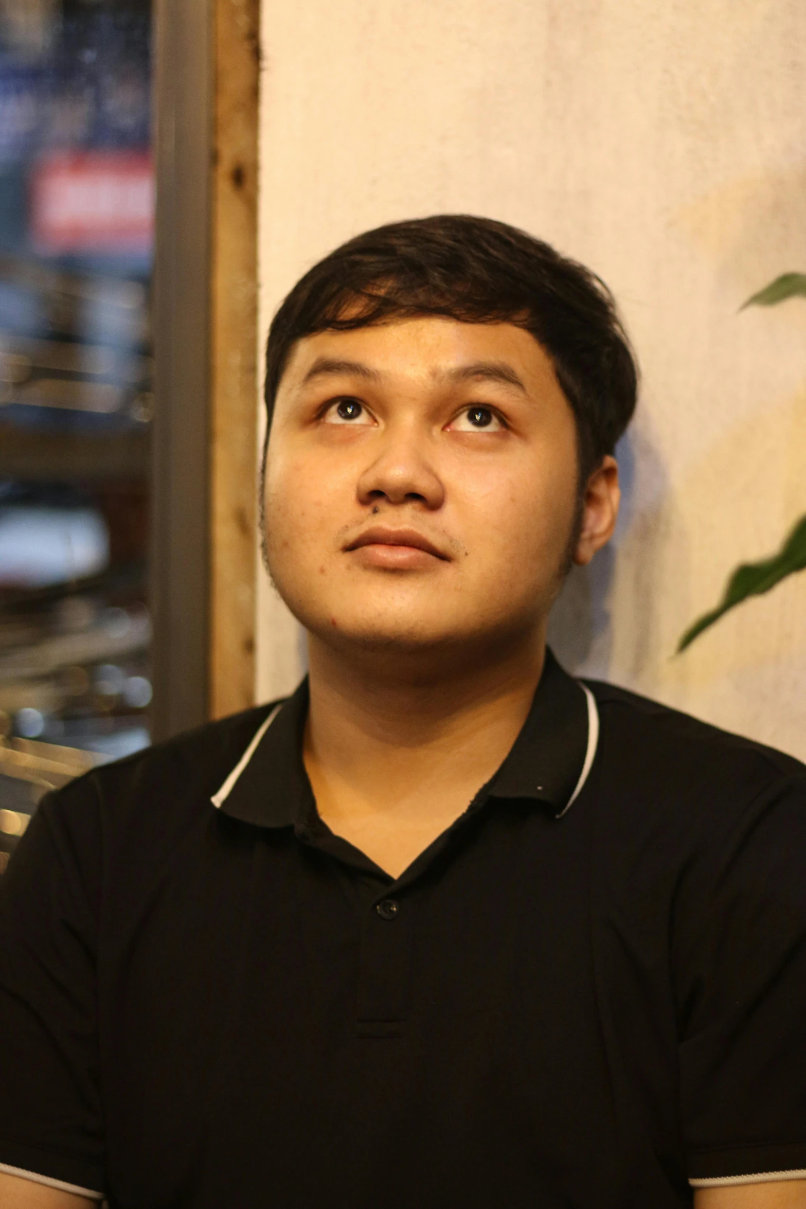 a young man is staring straight ahead while wearing a black shirt