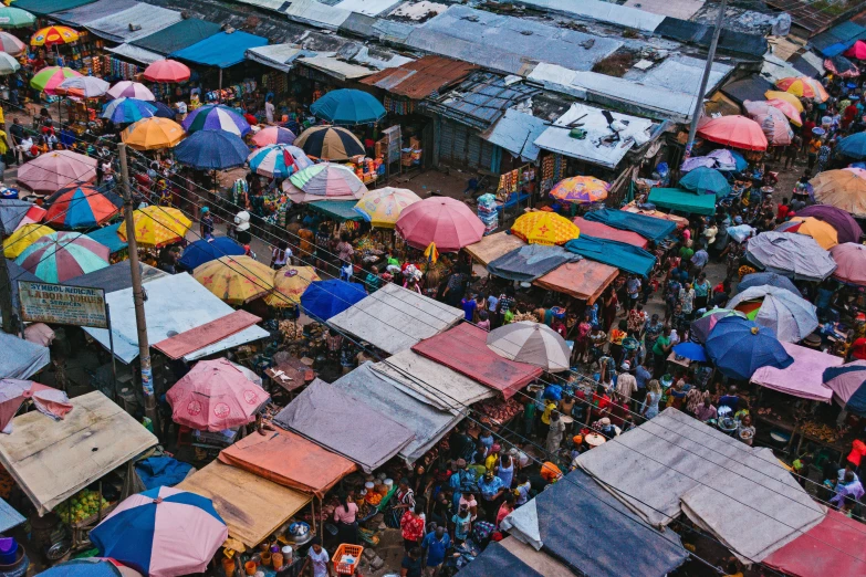 an aerial view of several stalls covered in umbrellas