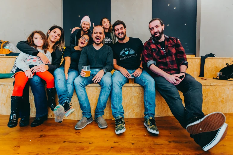 four people sit on a bench with their backs crossed