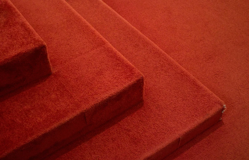 a close up of red colored steps, a very bright background