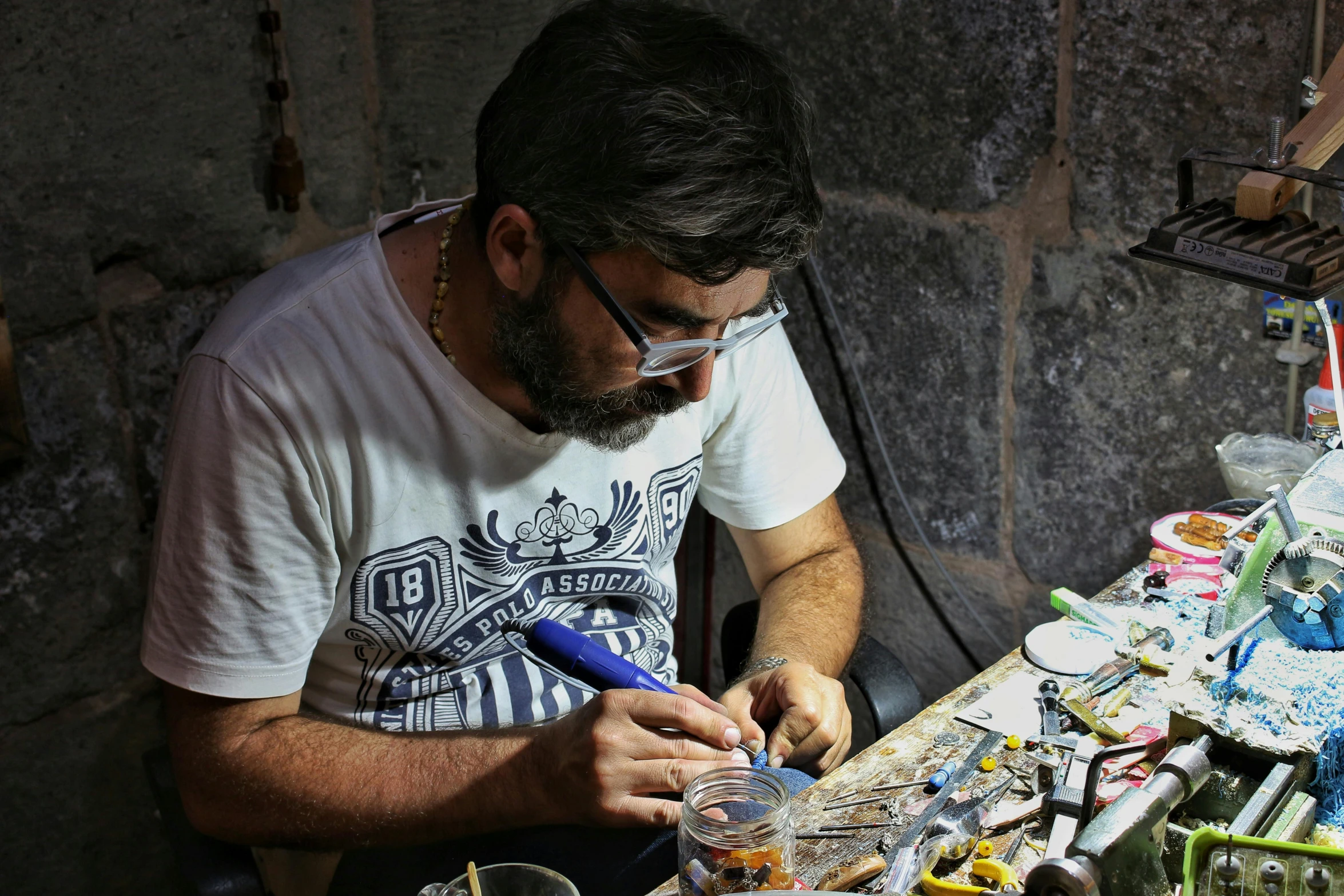 man doing crafts on a long wooden table