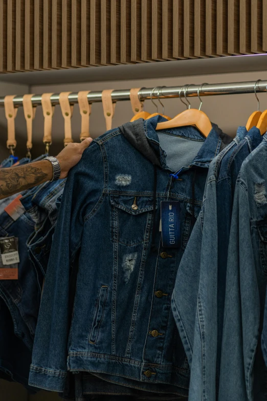 a closet of jeans and jackets hanging on the wall