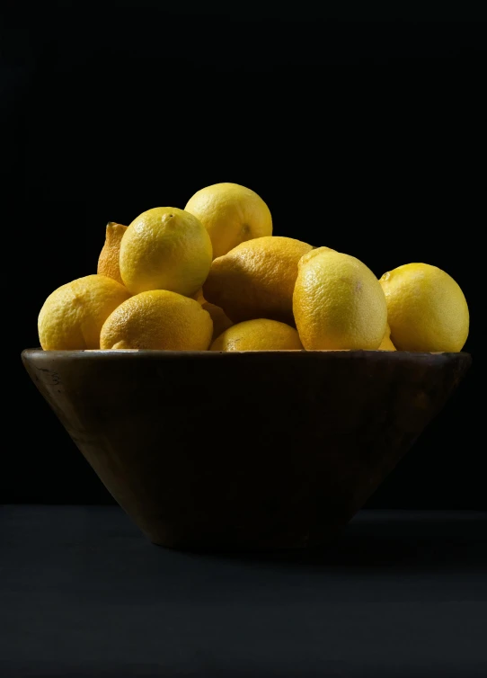 a bowl full of lemons sitting on a table