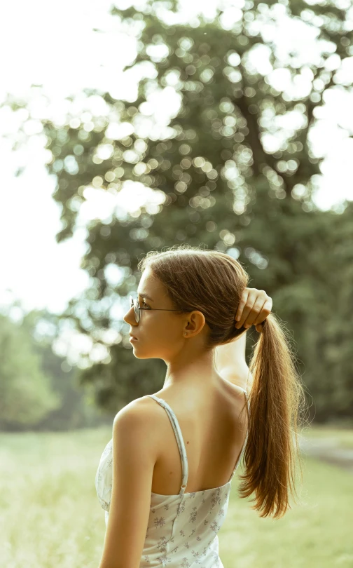 a woman in white dress holding a hair ponytail