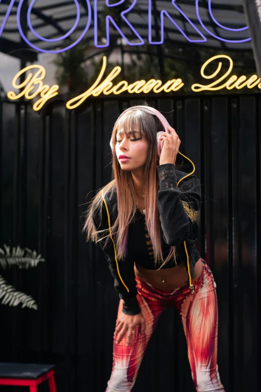 a woman with long hair standing in front of a neon sign