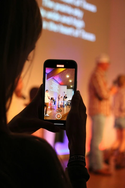 a woman taking a po on her cell phone of people