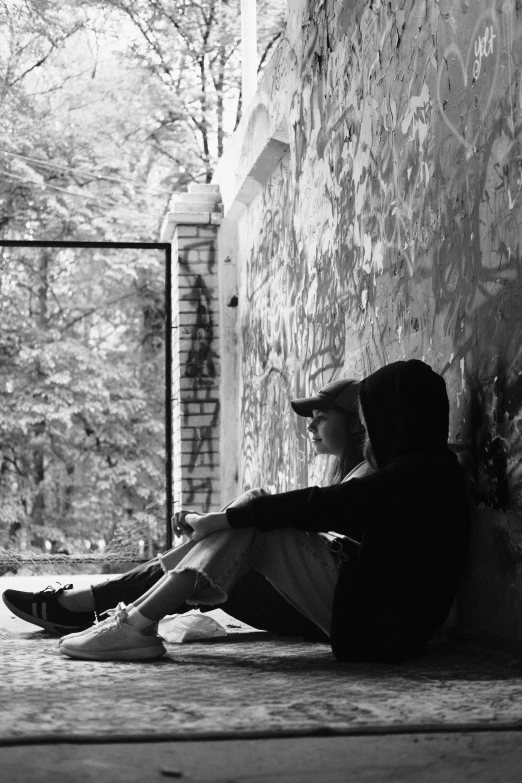 black and white pograph of a person sitting on the ground