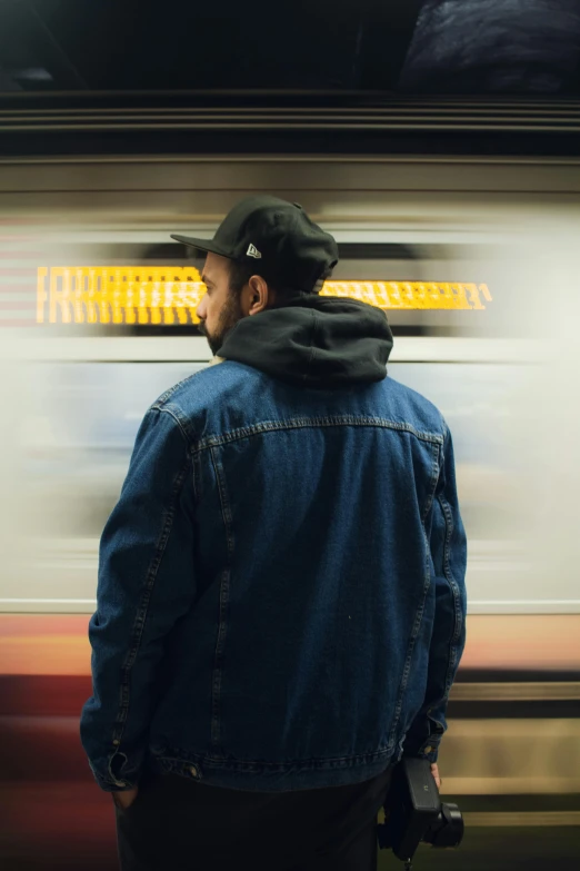 man standing in front of a subway train with the light shining through