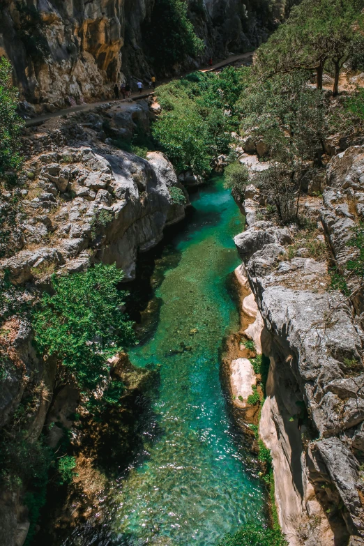a very pretty river surrounded by rocks with green water