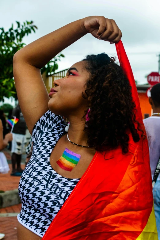 a woman is showing her skin and neck tattoos with a rainbow flag