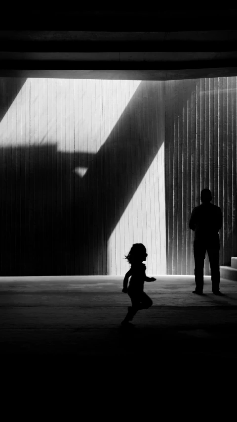 a man standing in an unfinished building with a shadow from a door