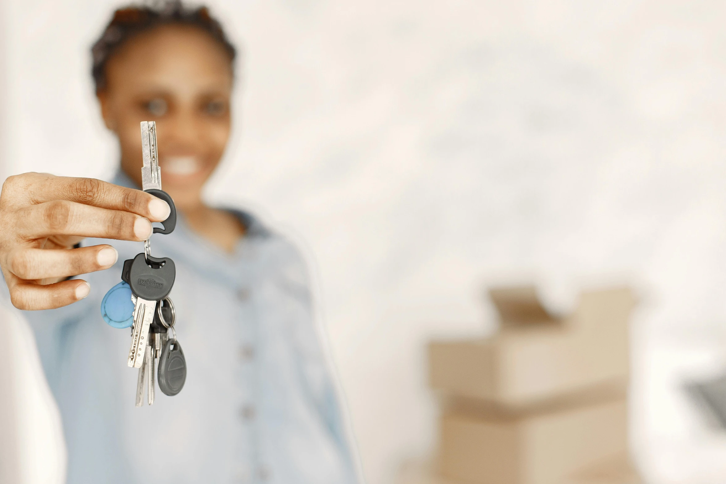 woman holding up four keys that she has for her new house