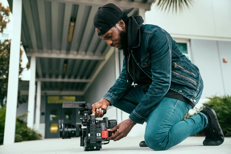 man kneeling down while he is setting up to take a po