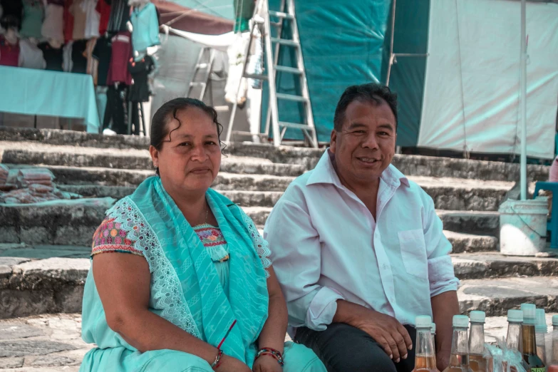 a man and woman sit next to each other on stone steps