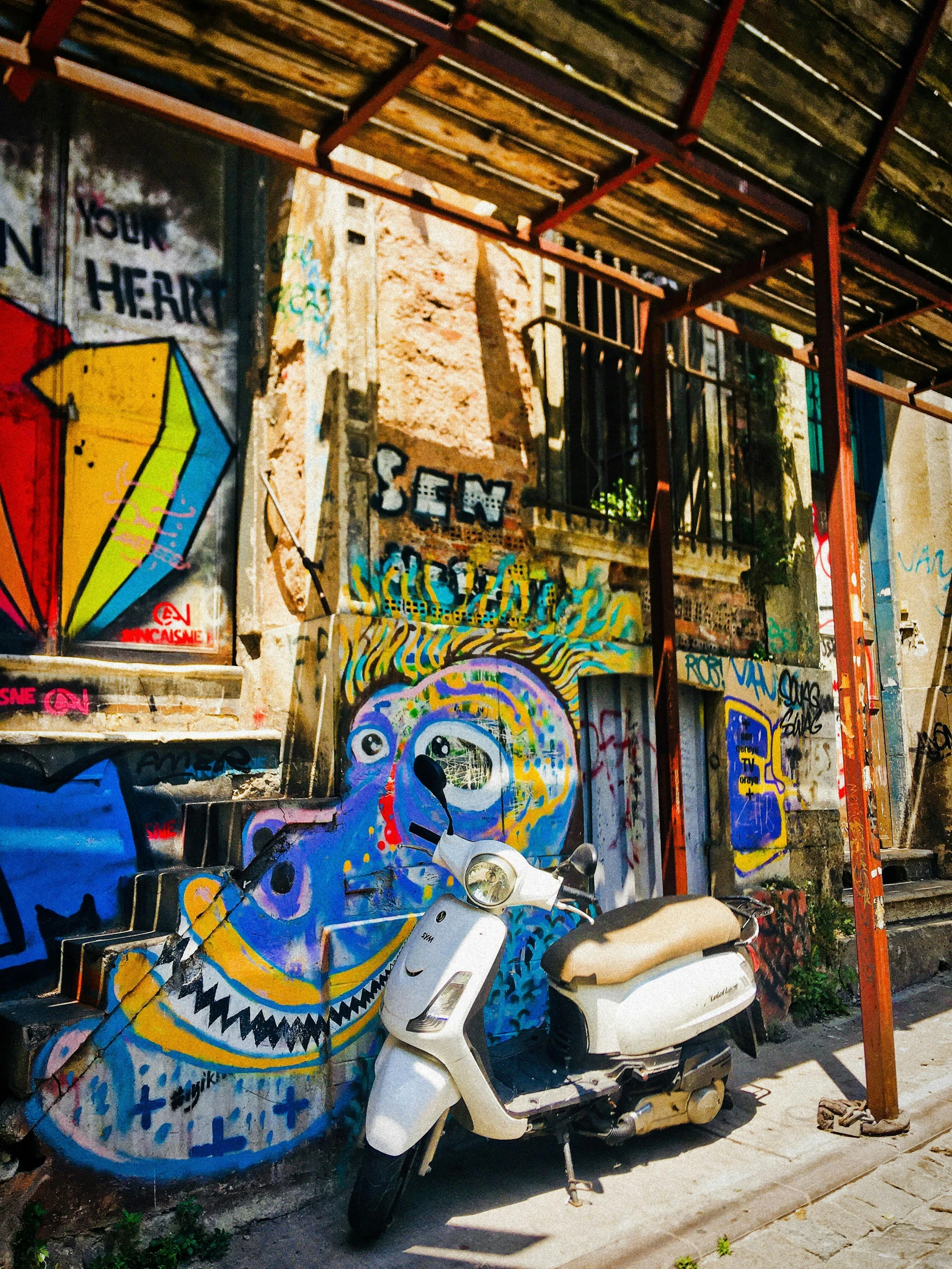 a scooter parked outside some graffiti covered buildings