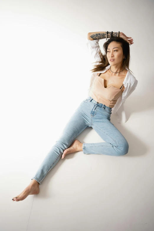 a woman leaning on the ground with a skateboard above her head