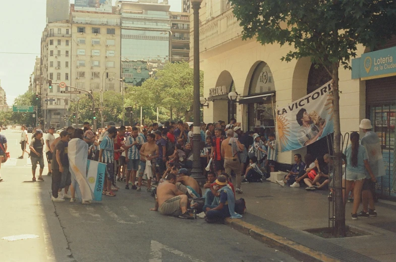 several people stand in a busy street near the water