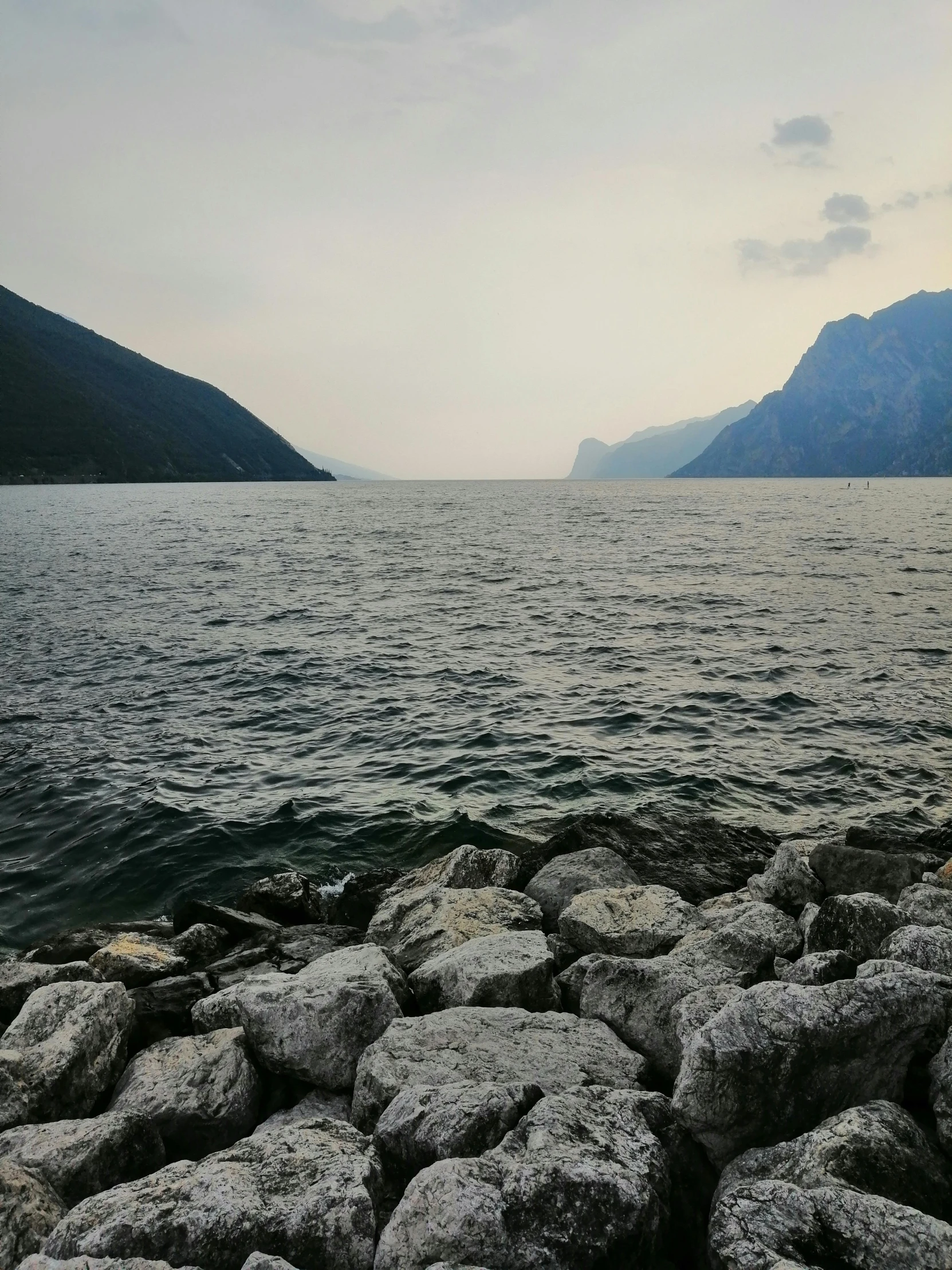 a calm, rocky body of water with mountain in the background