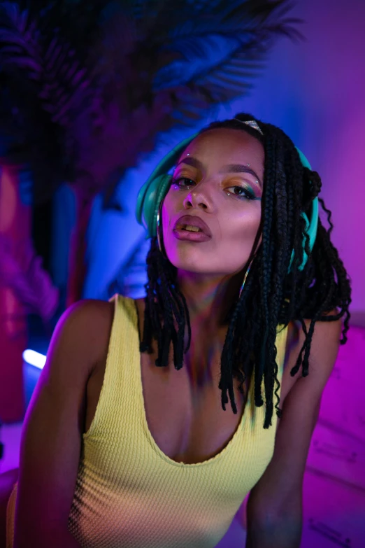 a woman wearing dread locks sitting in front of a window