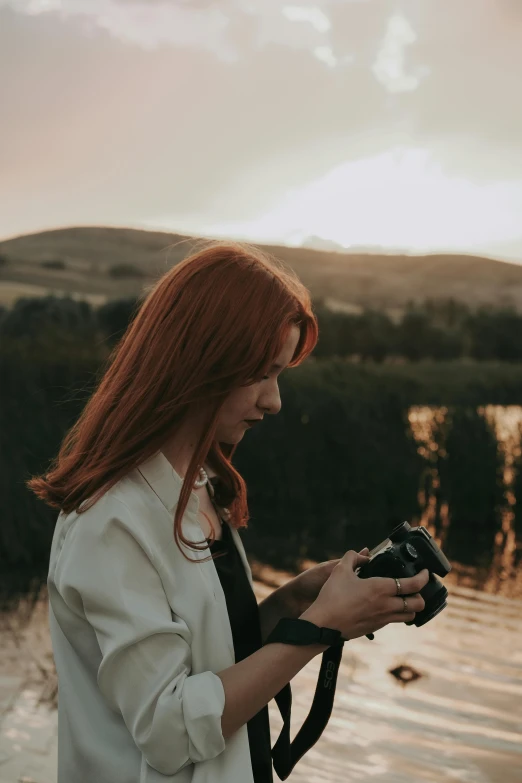 a woman with red hair holding a camera