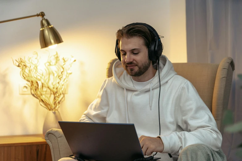 a man with headphones on working at a laptop