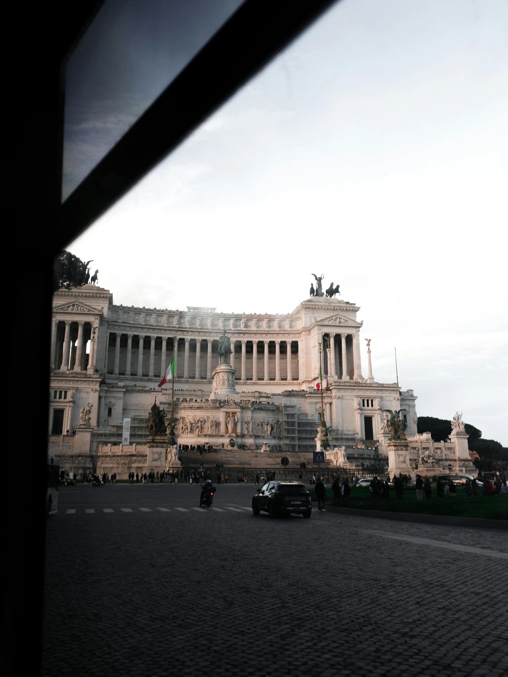 the car is driving outside the large building