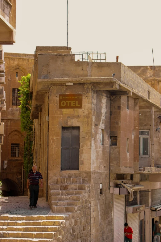 a man walking down a set of steps near a stone building