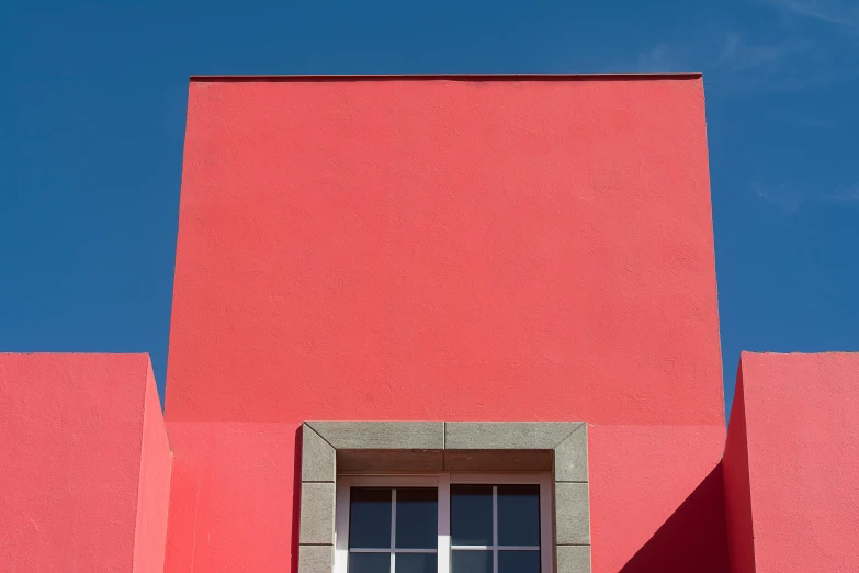 a window in the side of a red building