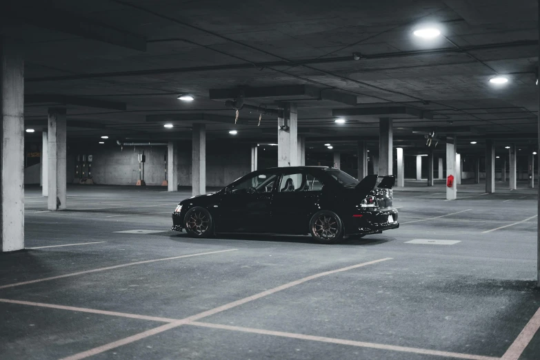 an open parking garage with a black car in it