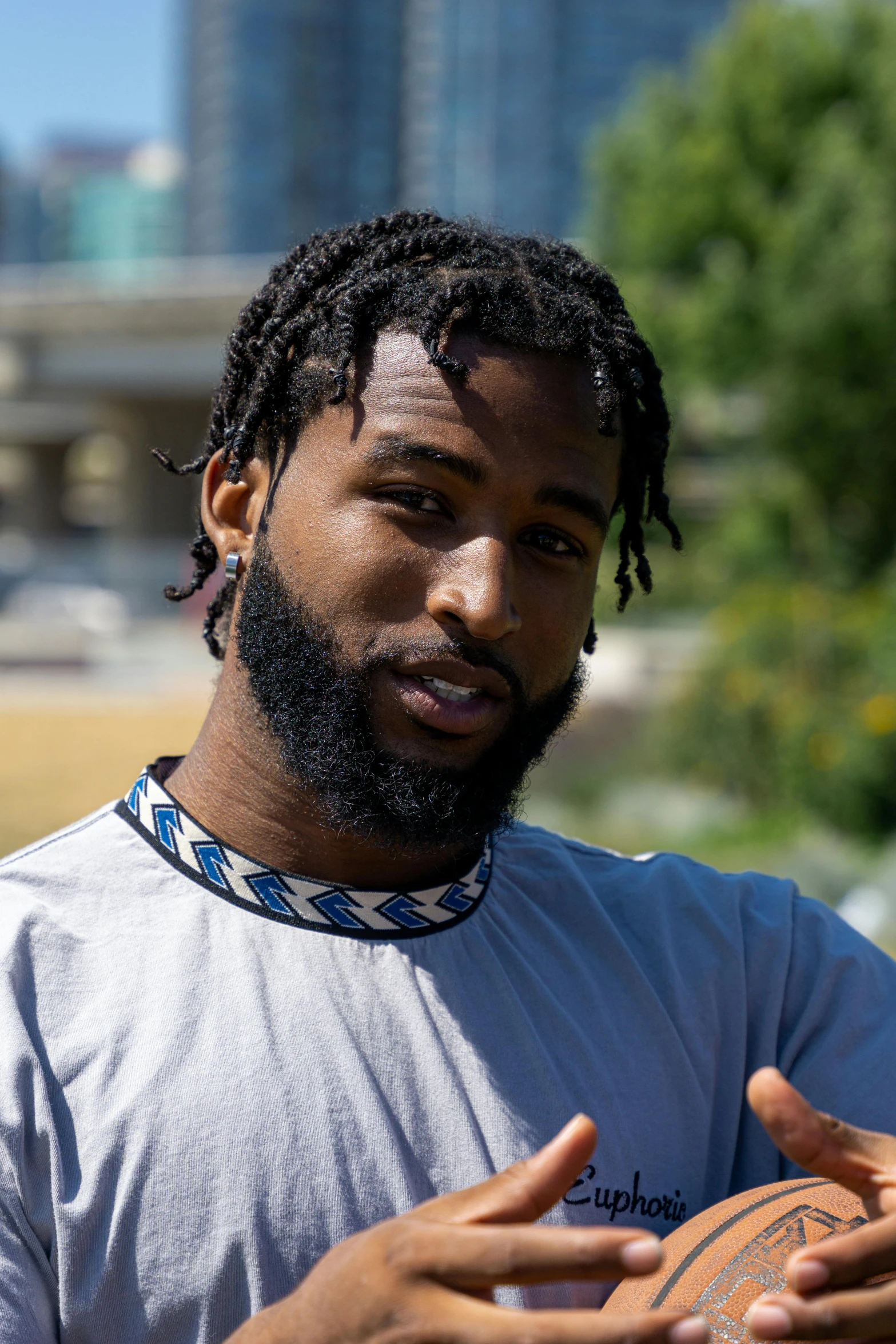 a man with dreadlocks holding a basketball in his hands