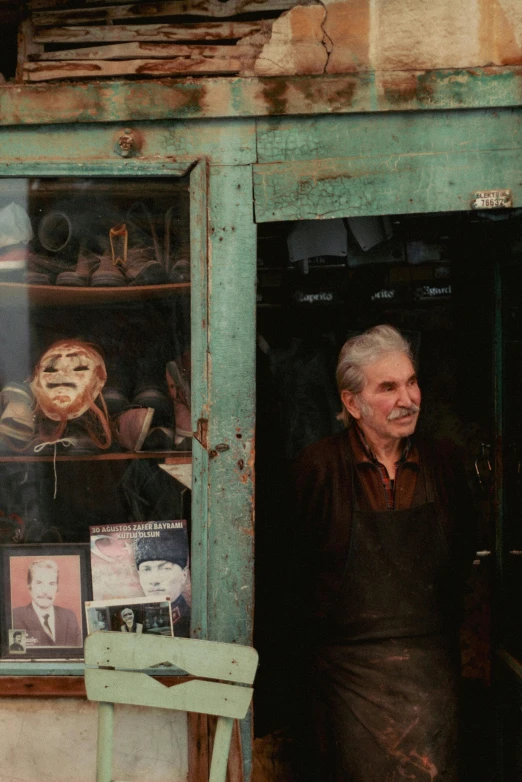 an elderly man looks out of a dilapidated window