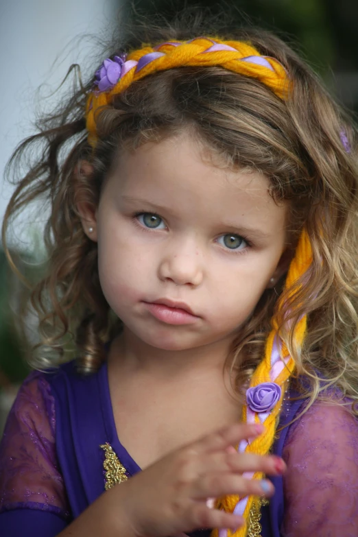 a little girl is wearing a flower in her hair