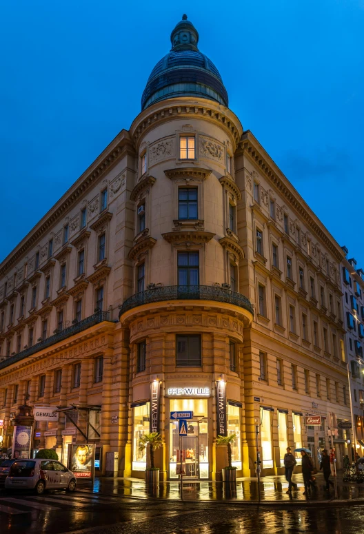 the corner of an old building at dusk in front of a street