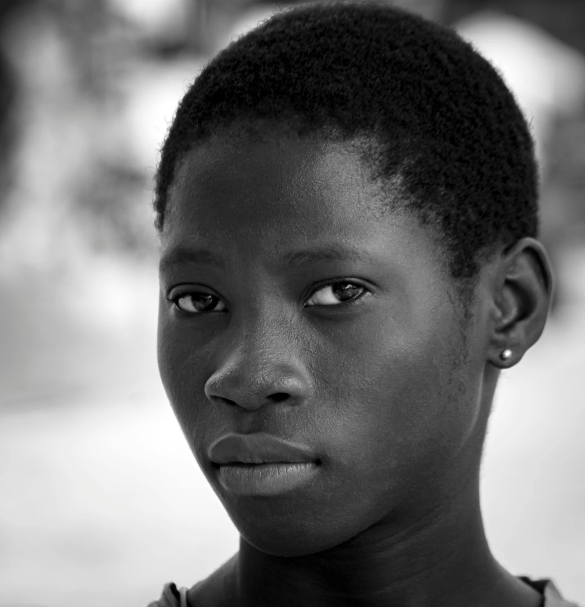 a girl with a dark skinned face stares at the camera