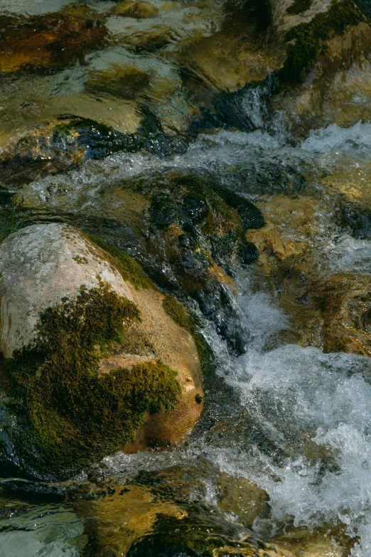 rocks in the water near a small waterfall