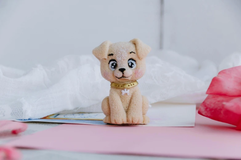 a small teddy bear sitting on top of a bed