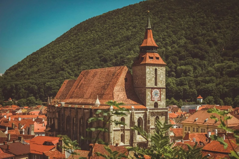 a tower with clocks stands in front of a hillside