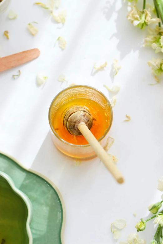 an aerial view of a cup of liquid with flowers next to it