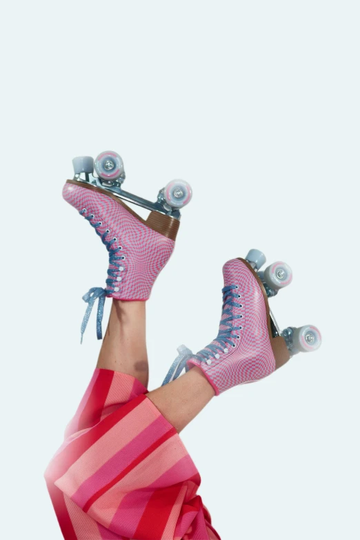 woman in pink dress balancing two skates with feet