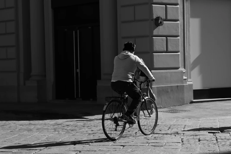 a person riding a bike on a cobblestone road