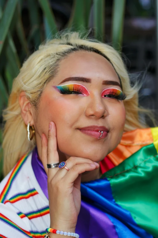 a woman poses for a po while wearing colorful makeup