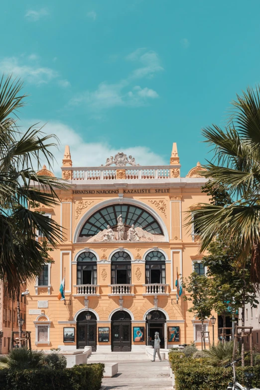 an old building is pictured with palm trees in front