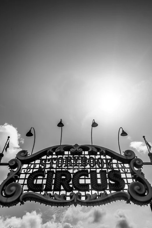 a sign advertising the circus under a sky with a light