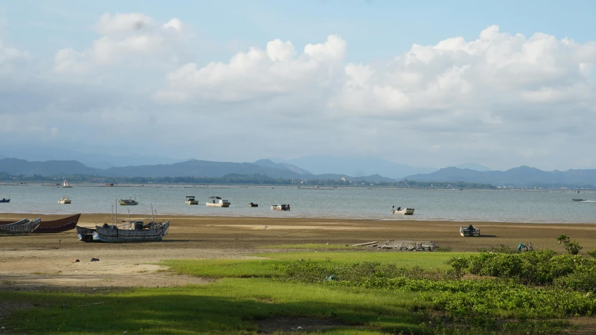 boats are floating on the water on a cloudy day