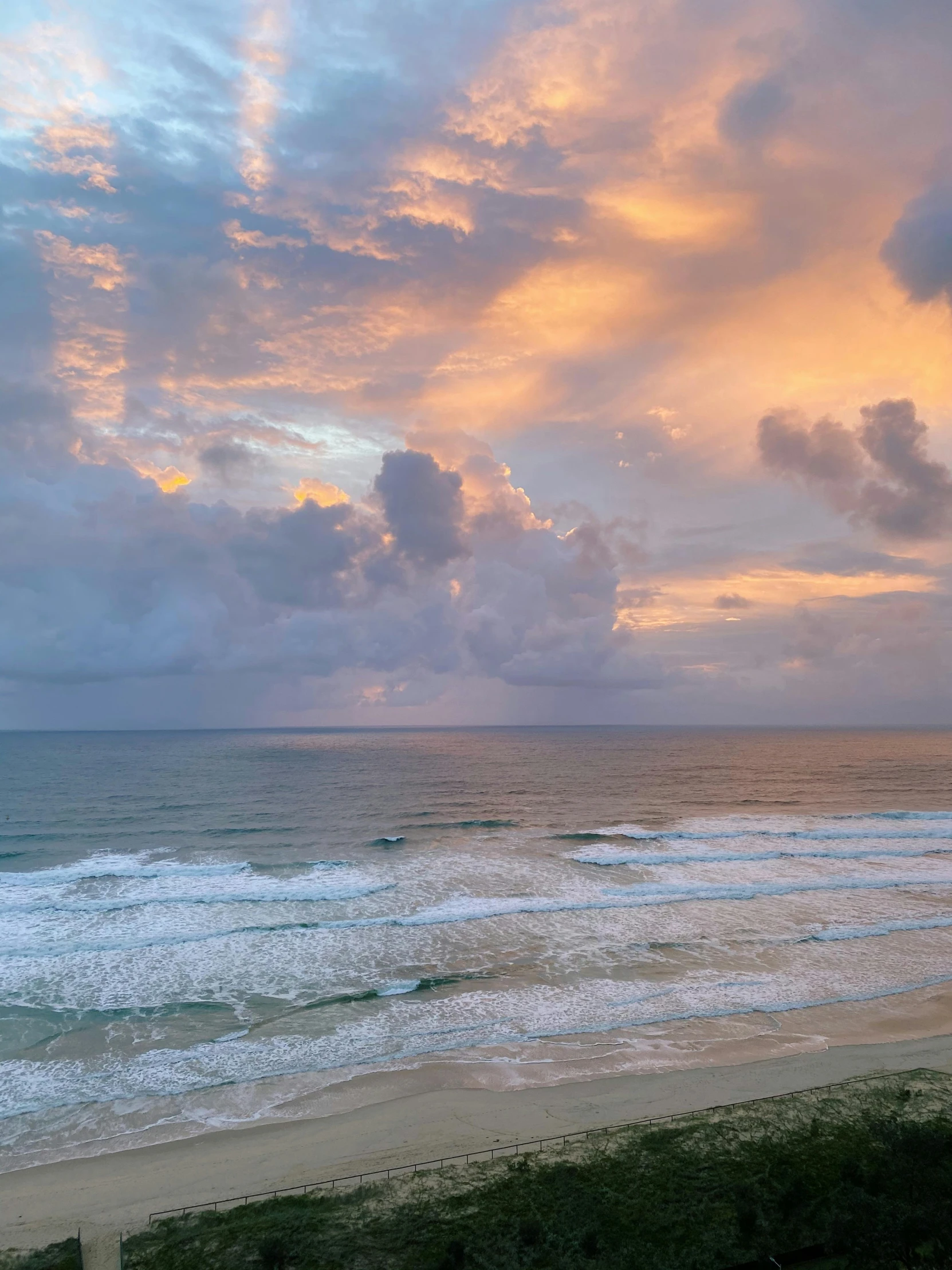 the sun is setting over the water at the beach