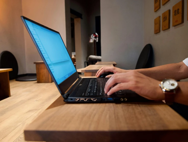 someone using a laptop computer at a coffee shop