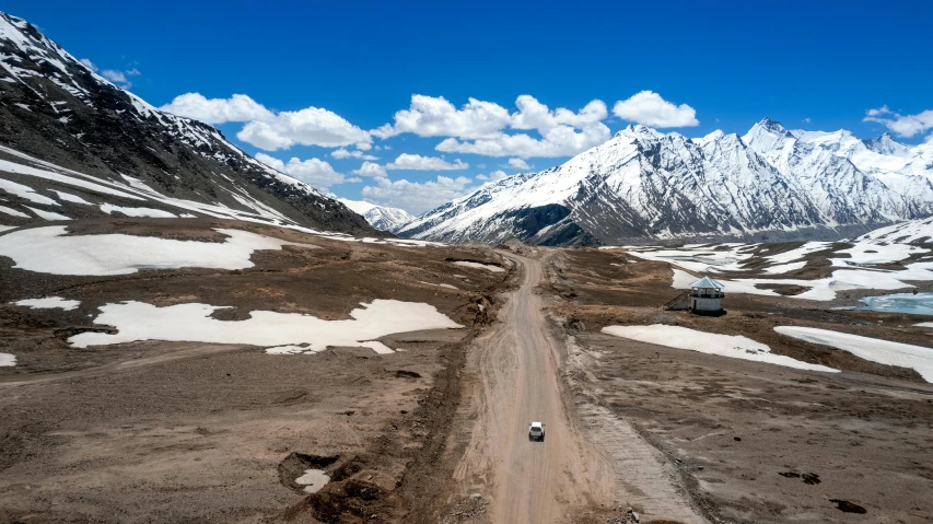 an suv is going down a road in the mountains