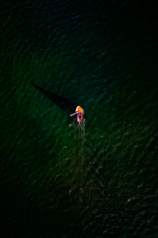 an overhead s shows the back of a small boat as it moves through the water