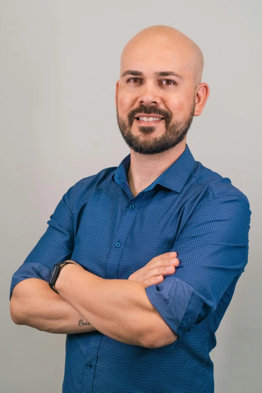 a man with his arms crossed looking into the camera